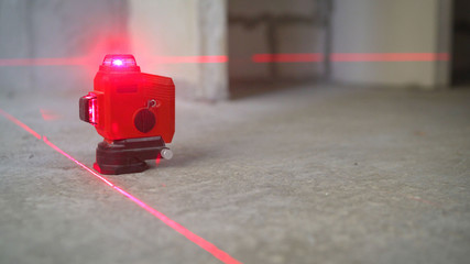 Laser level at work. Laser level and concrete walls and floor. Apartment renovation.
