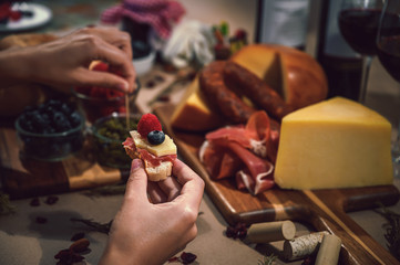 Serrano ham and cheese tapa and in the background a rustic table of gourmet ingredients