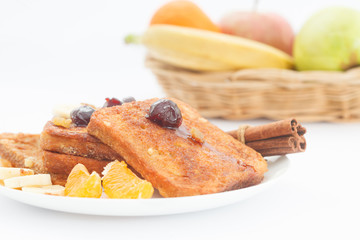 A plate of french toast with bananas, oranges and jam. Sweet breakfast with french toast and fruit.