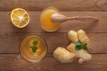 Ginger tea with lemon, honey and mint on a wooden table. Top view