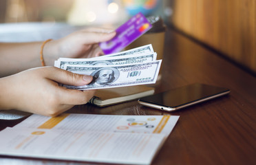 Closeup of girl hand holding hundred dollar and credit card.  Concept you can  payment or withdraw...
