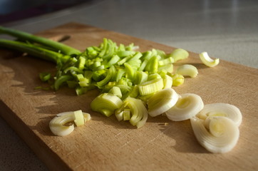 Fresh chopped leek on wooden board close up. Selective focus.