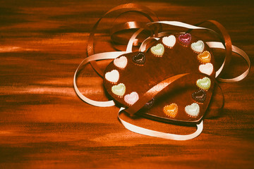 Red heart on a stylized gold textured background. White gift ribbon. Love and romance. Valentine's card. Concept.