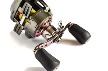Fishing Baitcasting Reel. Bottom part Low Profile Baitcasting Reel. Goods for fishing. Close-up of a fishing reel with yellow fishing line. Isolate on a white background. Selective focus. 