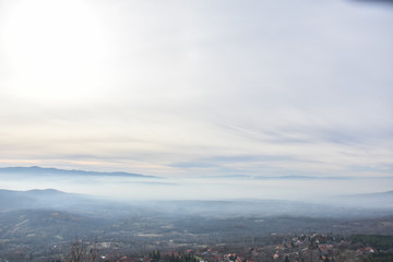 Environment pollution, foggy landscape of valley. Fog and pollution above the city of Nis, You...