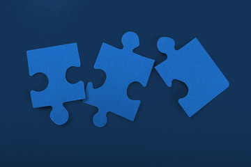 Puzzle pieces on classic blue background top view