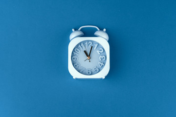 Top view of alarm clock on classic blue background