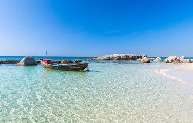 Fototapeta na wymiar Boat in blue sea and white sand beach.