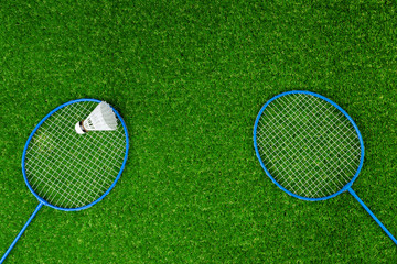 Badminton game rackets and shuttlecock on grass