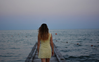 Fototapeta na wymiar the woman on the jetty at sunset