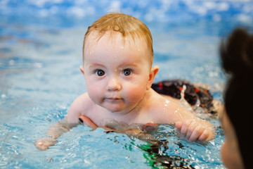 Fototapeta na wymiar Female and child swim in water pool.