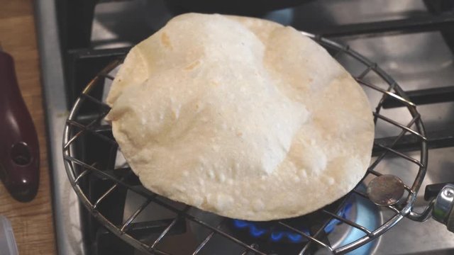 preparation of bread according to the Indian recipe. naan, chapati, poori. Fragrant flat Indian chapati breads with a light nutty aftertaste of whole grain flour. baking on open fire on grill.