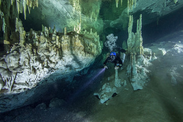 A cave diver swims in the Hulo cenote (Mexico), illuminated by the AMG's underwater light. Karst...