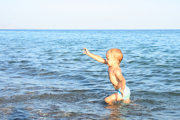 three year old little boy having fun at summer vacation in sea with his family