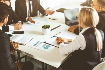 A team of young businessmen working and communicating together in an office. Corporate businessteam and manager in a meeting.