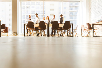 A team of young businessmen working and communicating together in an office. Corporate businessteam and manager in a meeting. desktop against the background of the pan window, free space for text