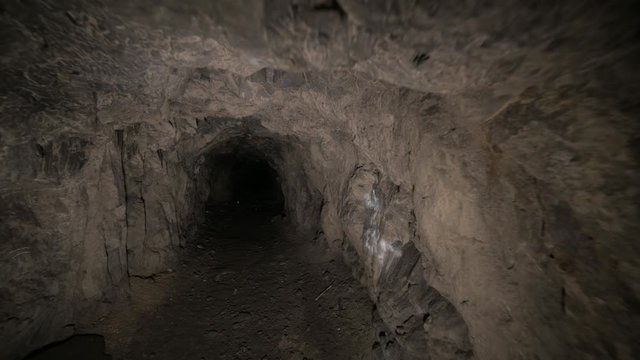 Speleology artificial cave dark tunnel excavation underground. Old adit for the extraction of metal and rocks
