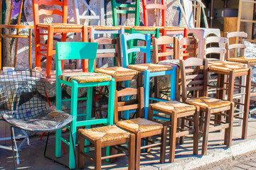 Fototapeta na wymiar Multi-coloured chairs sold on the street in Athens on a local market