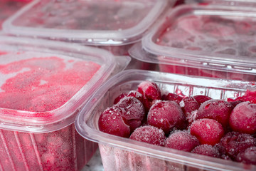 Frozen cherries  in plastic boxes. Natural ingredients of organic food for a healthy diet. Close up.