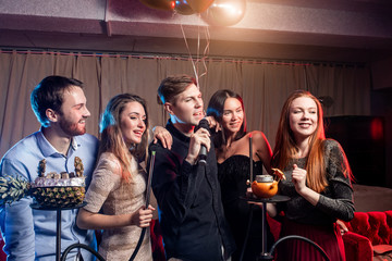 holiday, party,celebration concept. young people have cheerful pastime in karaoke, positive people together sing in microphone and have fun, chilling out