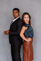Portrait of business mates and mixed race management team of african american man and caucasian woman posing on gray background. Concept of gender equality team leaders enthusiastic and diversity