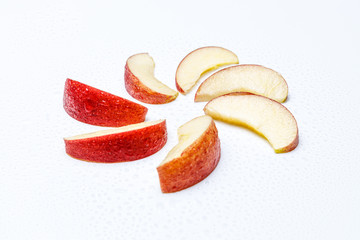 Roter Apfel mit Wasser Perlen in Stücken zusammengelegt zu einer Sonne