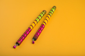 Dandiya sticks on a yellow background. Raas Garba or Dandiya Raas is the traditional folk dance...