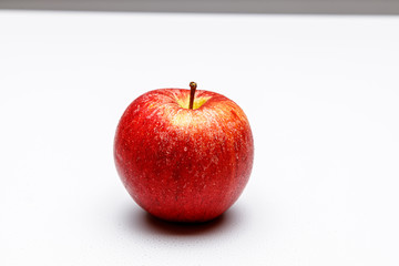 Ein  frischer roter Apfel auf weißen Hintergrund mit kleinen Wasser tropfen