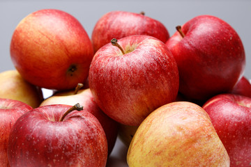 Fototapeta na wymiar Frische rote Äpfel gestapelt auf grauen Hintergrund close up