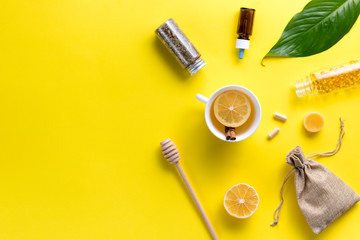 Illness concept. Composition alternative medicine. Herbal tea, ginger and lemon on a yellow background. Child's health. Flat lay. View from above. Copy space