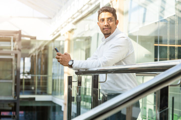 Portrait of a businessman in suit are standing on the background of glass offices.