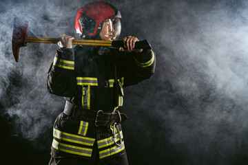 Fototapeta premium reverent, confident man working in fire station ready to save people from fire in emergency situations, wearing uniform and helmet
