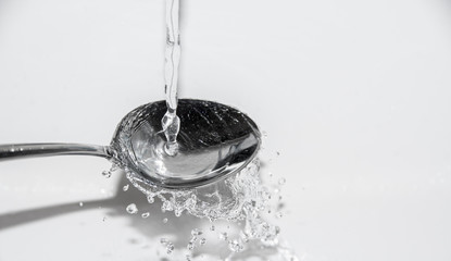 Löffel mit spritzender Flüssigkeit - wasser