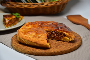 An Australian meat pie. A slice is missing.
