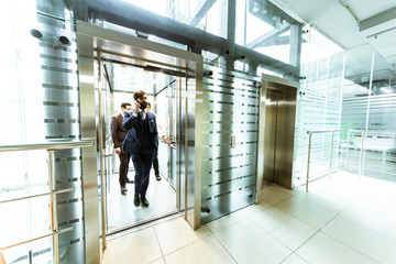 Business team group going on elevator. Business people in a large glass elevator in a modern office. Corporate businessteam and manager in a meeting.