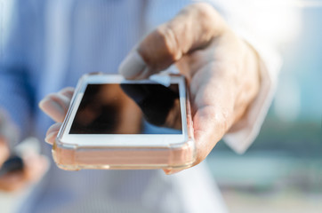 5G technology world wide web connecting.close up business man using hand typing smartphones and touch screen working search with app devices outdoor in city with sunrise and building background.
