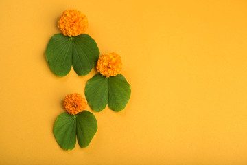 Indian Festival Dussehra, showing golden leaf (Bauhinia racemosa) and marigold flowers on a yellow...