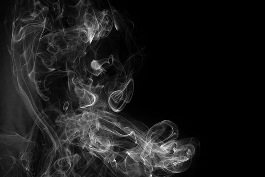A close up macro photo of incense smoke in black and white to create a moody glow overlay with copy space