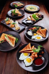 Breakfast food table. Festive brunch set, meal variety with fried egg, pancakes, croissants, smoothie ,fresh berries and fruits. Overhead view