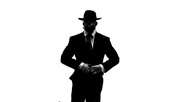 Silhouette Elegant man in a black hat is dancing an erotic dance. He uses a chair and a cigarette. White background. Close up, slow motion.