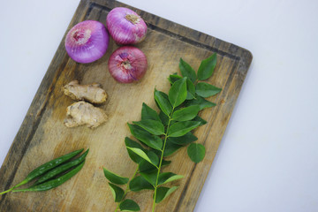 Fresh ingredients for cooking with onions, ginger and curry leaves.