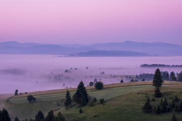 Sunrise on the mountain with morning fog in the valley.