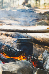 Cooking in a cauldron over campfire. Cauldron on fire. Preparing for a delicious dinner. Trip to...