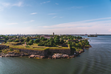 Suomenlinna fortress on a summer day with city behind it in distance, Helsinki Finland