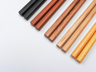 Top view of five color wooden chopsticks are arranged in parallel isolated on white background. Main tableware in East and Southeast Asia. Traditional culture and lifestyle concept. With copy space.
