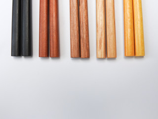 Top view of five color wooden chopsticks are arranged in parallel isolated on white background. Main tableware in East and Southeast Asia. Traditional culture and lifestyle concept. With copy space.