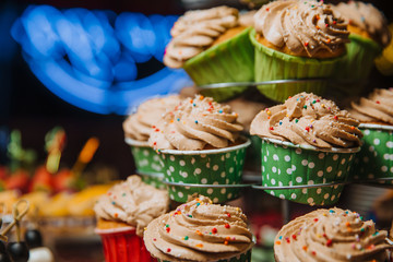 Freshly made cupcakes stand on a stand.