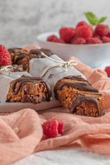 Cereal bars with raspberries on kitchen counter top.