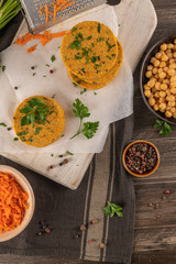 Raw veggie burger with chickpeas, vegetables and parsley leaves on kitchen countertop