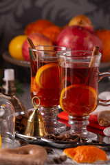Two glasses with mulled wine on a tray with christmas accessories